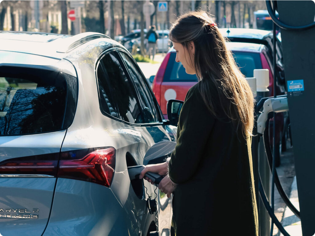 EV driver charging her car at a charging station